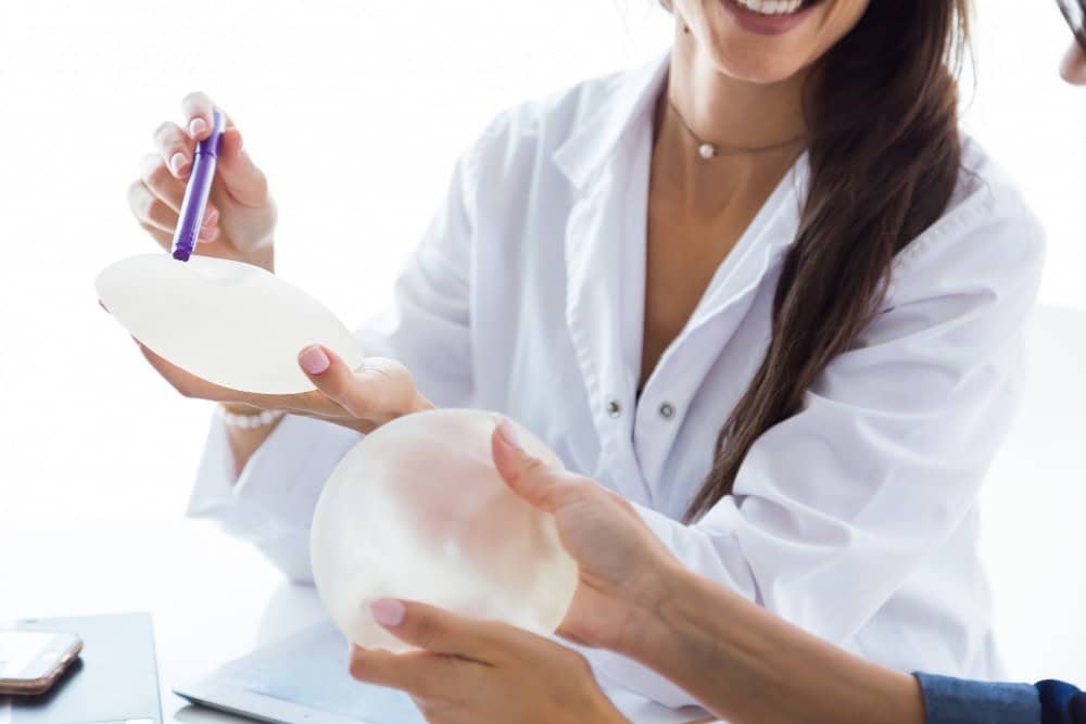 Plastic surgeon explaining breast implant options during a breast augmentation consultation in Albania